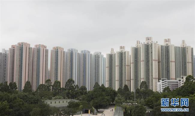 这是位于天水围的香港湿地公园和身后的天水围公共屋邨（5月22日摄）。 　　“1997年香港回归那天，下了一场大雨。回归之后的天水围如雨后春笋般迅速发展壮大。”55岁的天水围居民陈志展对这片土地情有独钟，说起天水围周边的丫髻山、龙园、湿地公园，他如数家珍。作为香港第三代新市镇，天水围曲折的发展路径和其回归以来20年的变迁很有代表性。新华社记者近日三次走进天水围，搭轻铁、进街市，采访扎根当地20余年的区议员，入户访问当地老住户，亲身感受天水围的生活质感。新华社记者刘昀摄